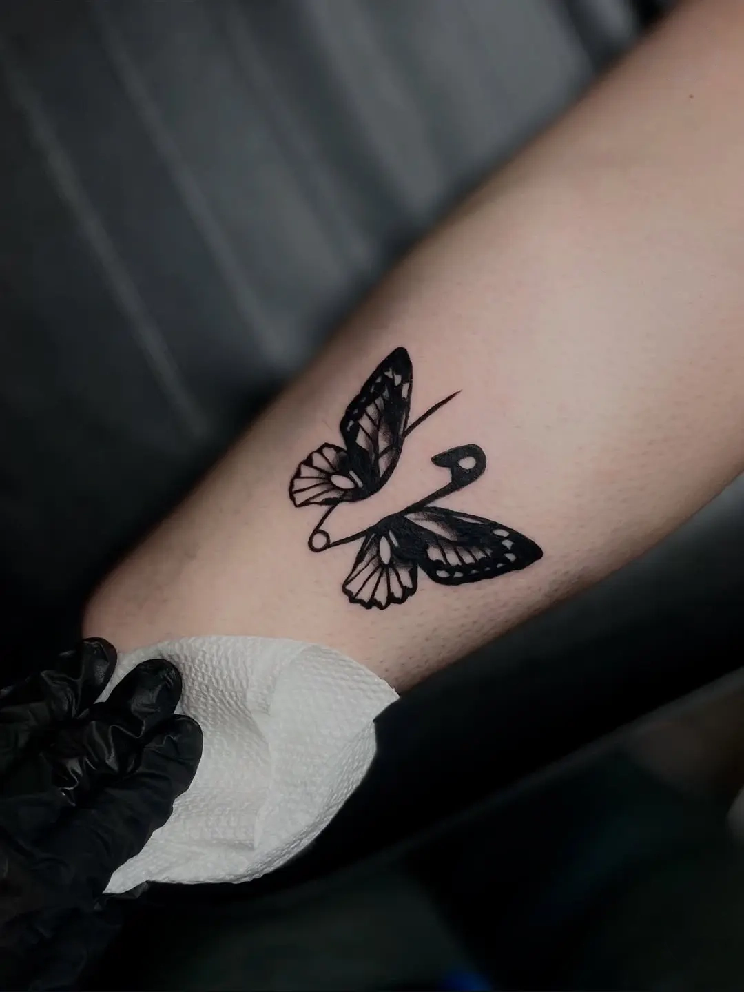 Black ink butterfly tattoo shown on the studio website.
